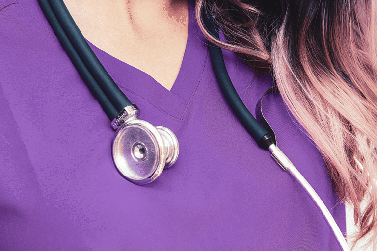close up of nurse wearing purple scrubs