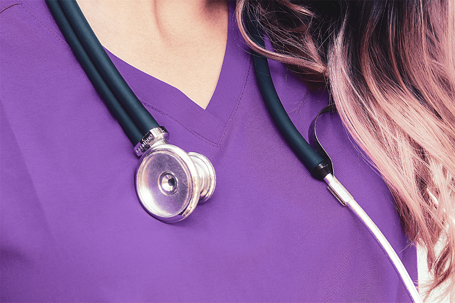 close up of nurse wearing purple scrubs